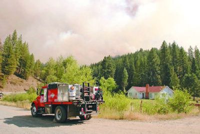 
Smoke looms behind a house near Pomeroy, Wash., in 2005 as the School Fire burns in the hills. Scientists say global warming could cause worse wildfire seasons in the West, as snowpacks melt earlier, leaving dryer conditions.
 (File Associated Press / The Spokesman-Review)