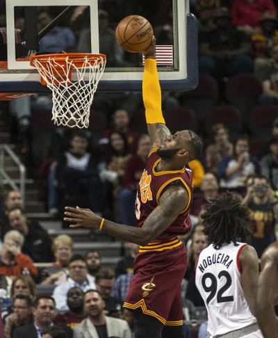 Cleveland Cavaliers' LeBron James makes a basket as Toronto Raptors' Lucas Nogueira watches during the first half of an NBA basketball game in Cleveland, Tuesday, Nov. 15, 2016. (Phil Long / Associated Press)