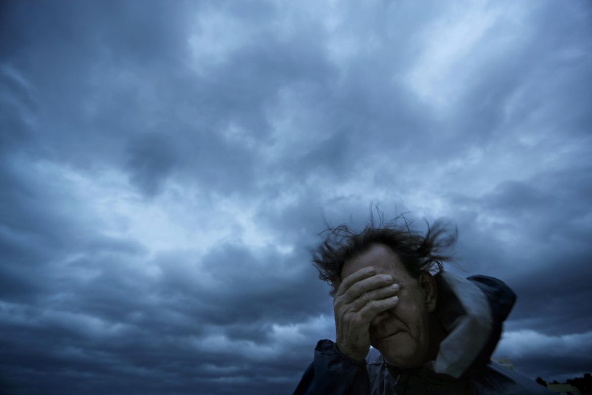 Russ Lewis covers his eyes from a gust of wind and a blast of sand as Hurricane Florence approaches Myrtle Beach, S.C., Friday, Sept. 14, 2018. When Florence touched down, it had been reduced to a Category 1 according to the Saffir-Simpson scale. On AccuWeather’s new hurricane scale, RealImpact Scale for Hurricanes being launched this year, would have categorized Florence as an RI4. (David Goldman / Associated Press)