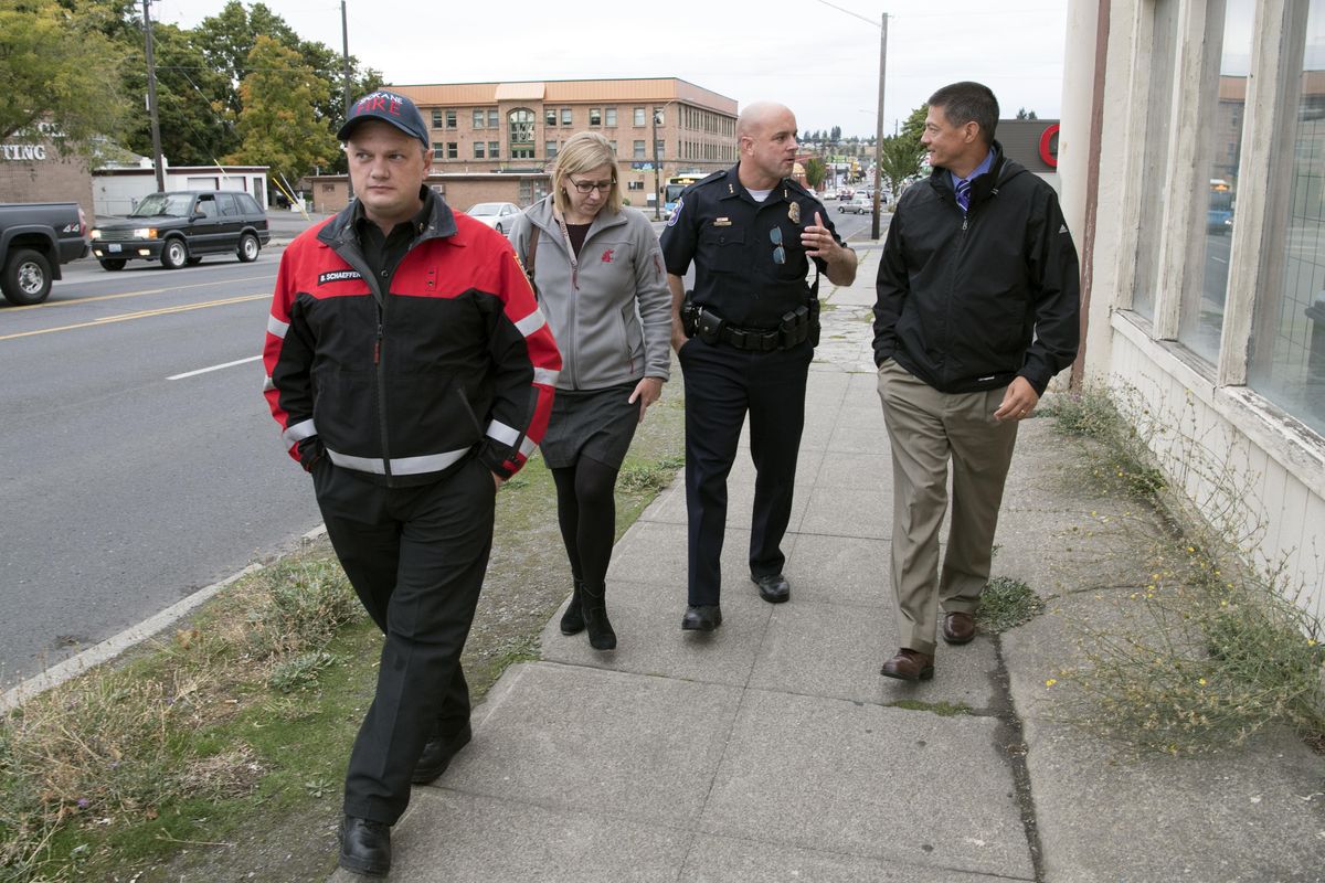 Spokane Fire Chief Brian Schaeffer, left, Marlene Feist of the City Public Works and Utilities department, Spokane Police Chief Craig Meidl and city spokesman Brian Coddington walk along North Monroe Street and talk about the planned traffic revisions to take place soon. Photographed Monday, Oct. 2, 2017. (Jesse Tinsley / The Spokesman-Review)