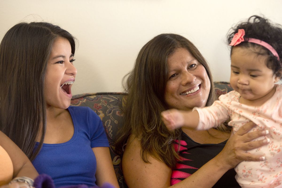 Irene Gonzales, center, sits with daughter Kimiko, left, and niece Savannah while watching a “Today” segment about her accomplishments on Aug. 8. (Jesse Tinsley)