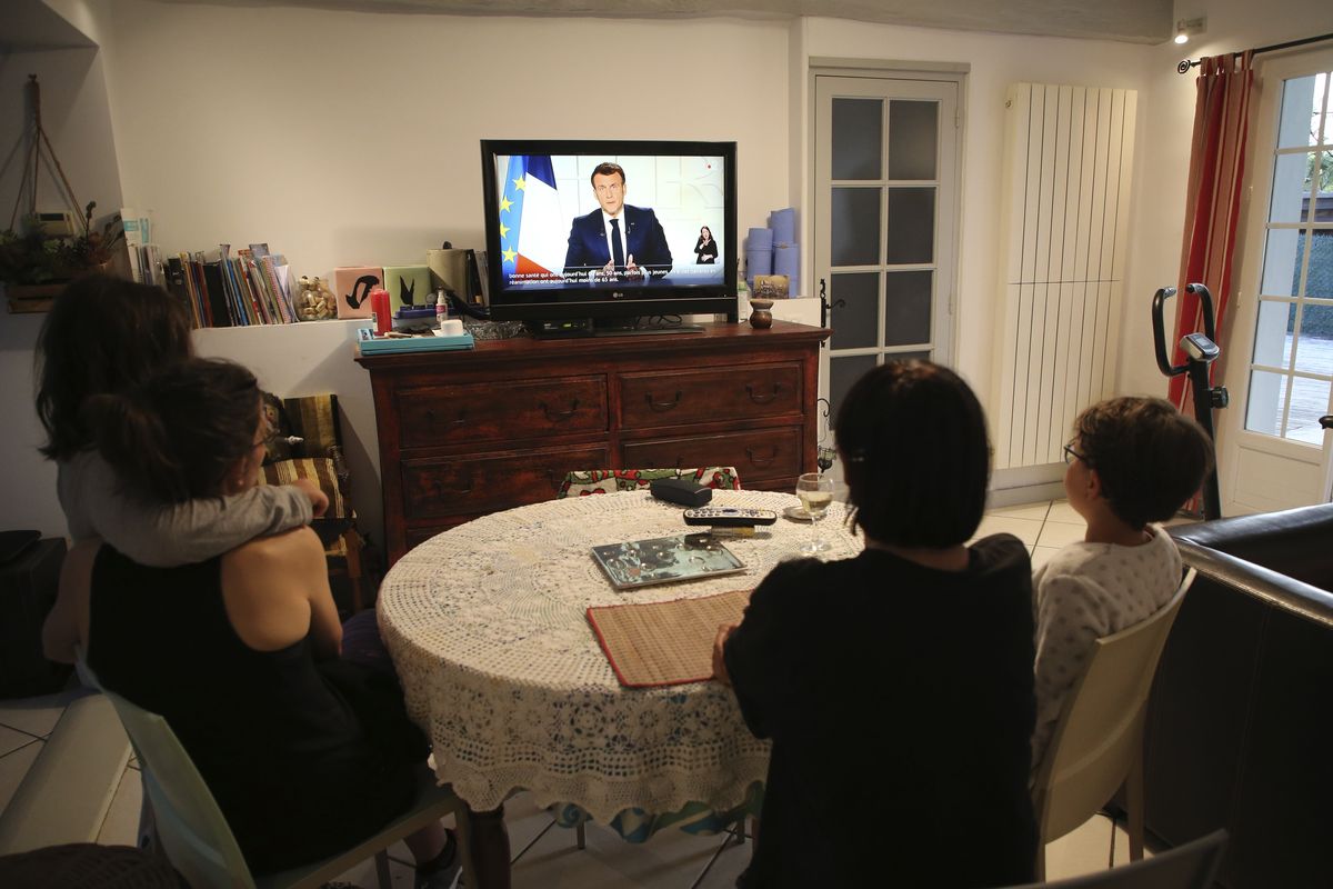 The Larragana family watch French President Emmanuel Macron addressing the nation in Ascain, southwestern France, Wednesday, March 31, 2021. French President Emmanuel Macron is expected to impose new virus restrictions in a televised address to the nation Wednesday night, amid growing pressure to act more boldly to combat surging coronavirus hospitalizations.  (Bob Edme)