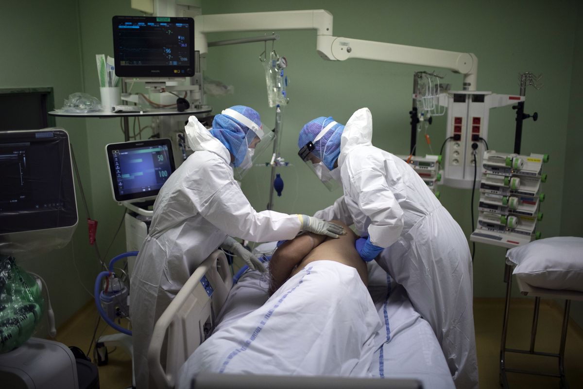 A medical crew treat a COVID-19 patient in the intensive care unit at the Joseph Imbert Hospital Center in Arles, southern France, Wednesday, Oct. 28, 2020. Many French doctors are urging a new nationwide lockdown, noting that 58% of the country's intensive care units are now occupied by COVID patients and medical staff are under increasing strain.  (Daniel Cole)