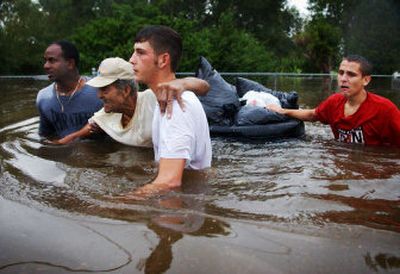 
Lester Levene, left, and Dustin Hymel, 19, help their elderly neighbor George Readom leave his home in Abbeville, La., on Saturday in Hurricane Rita's floodwaters.
 (Associated Press photos / The Spokesman-Review)