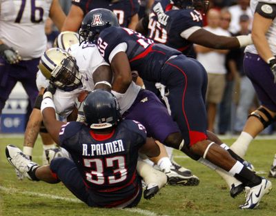 Brandon Johnson, center, and the Huskies fell to 0-5 after being brought down by Arizona all night.  (Associated Press / The Spokesman-Review)