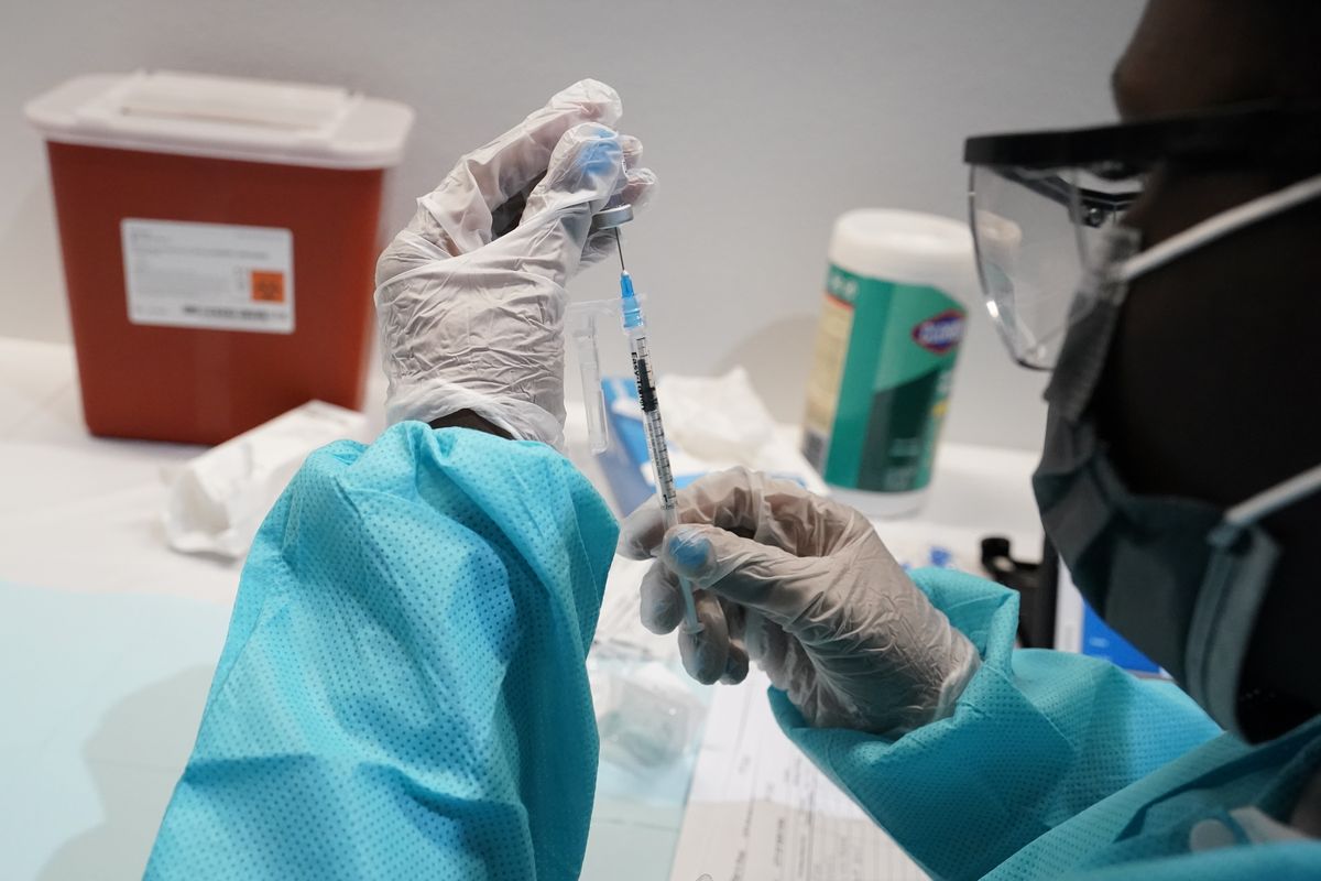 A health care worker fills a syringe with the Pfizer COVID-19 vaccine Thursday at the American Museum of Natural History in New York.  (Mary Altaffer)