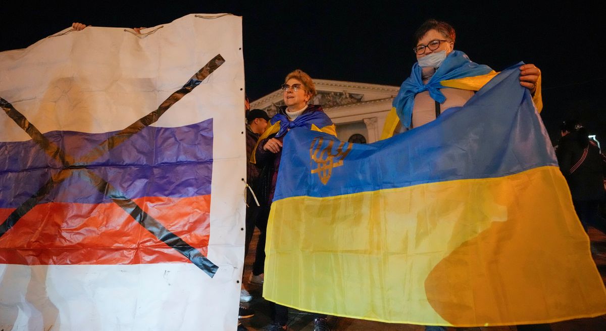 FILE - Ukrainians hold up their country
