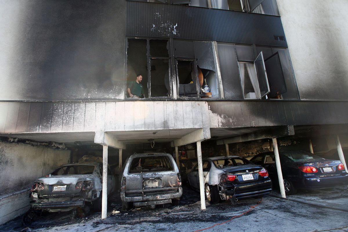 An investigator works the scene where fire caused damage to a two-story apartment at 1156 N. Cahuenga Blvd. in Hollywood on Friday. (Associated Press)
