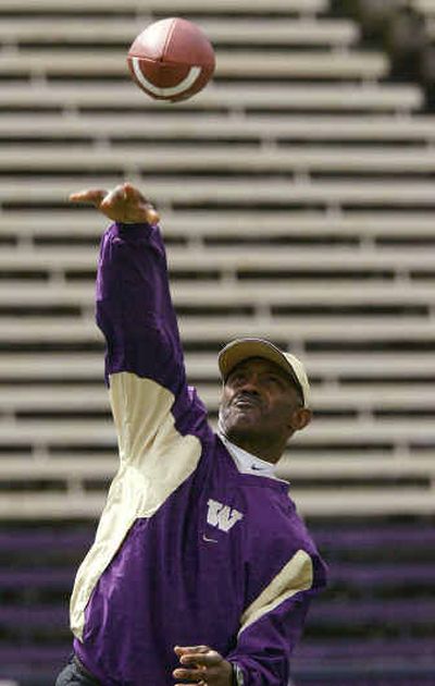 
UW football coach Tyrone Willingham throws to UW basketball coach Lorenzo Romar before filming a TV commercial. 
 (Associated Press / The Spokesman-Review)