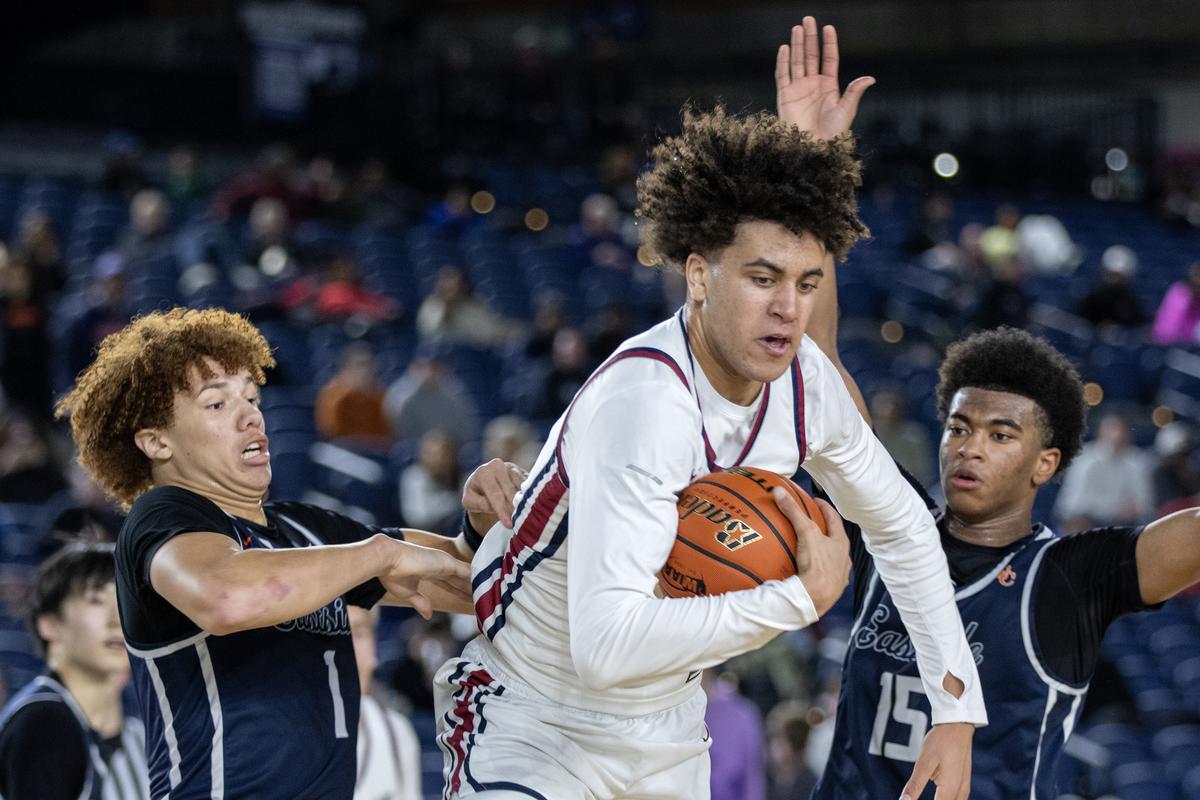 Mt Spokane’s Jaden Ghoreishi, middle, busts between the defense of Eastside Catholic’s Tytan McNeal, left, and Anthony Williams during a Class 3A state boys basketball game on Thursday at the Tacoma Dome.  (Patrick Hagerty/For The Spokesman-Review)