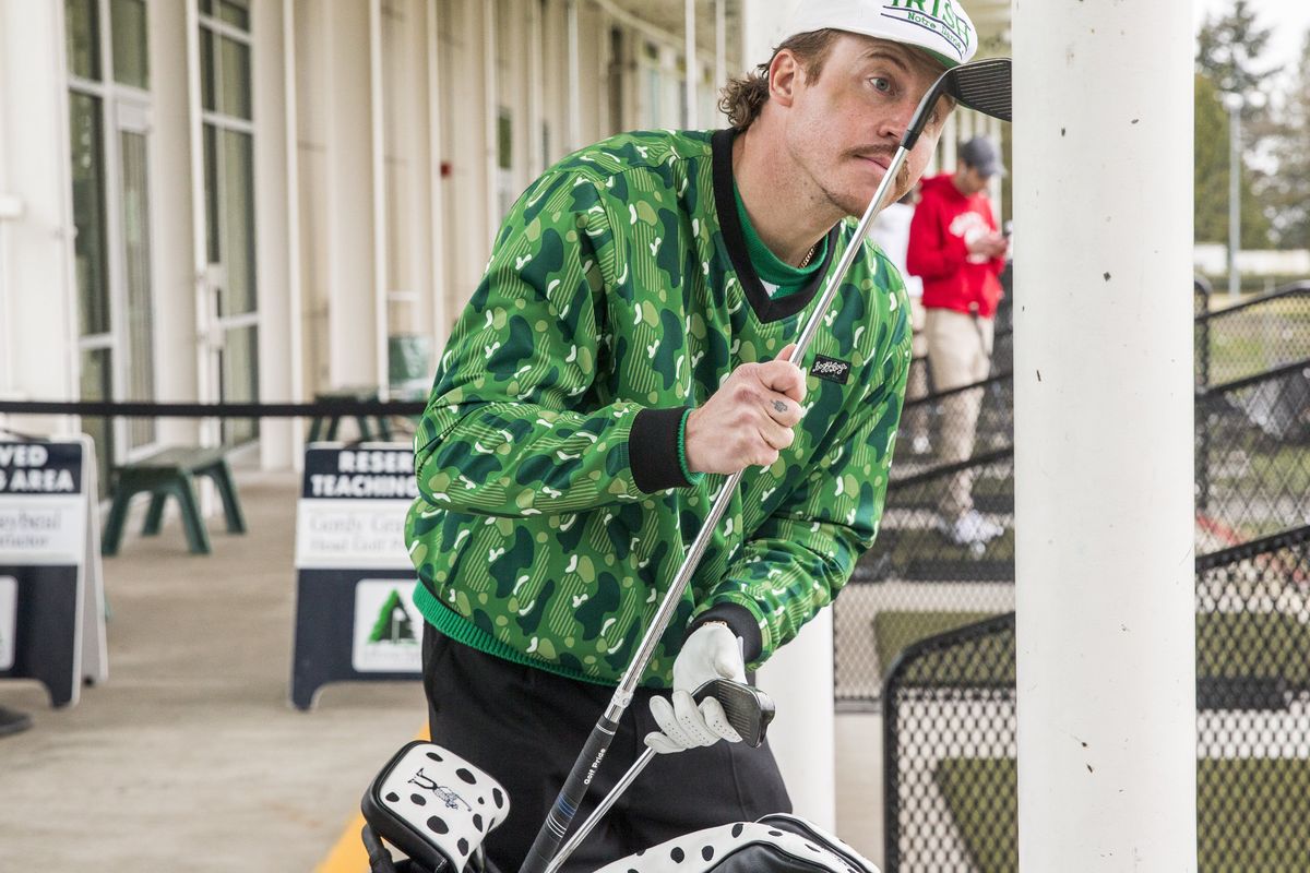 Ben Haggerty, known professionally as Macklemore, picks out a new golf club to hit at Jefferson Park driving range. In the last few years, Macklemore has become obsessed with golf and launched a new apparel golf line, Bogey Boys, last week. Thursday, Feb. 18, 2021 216410  (Amanda Snyder)