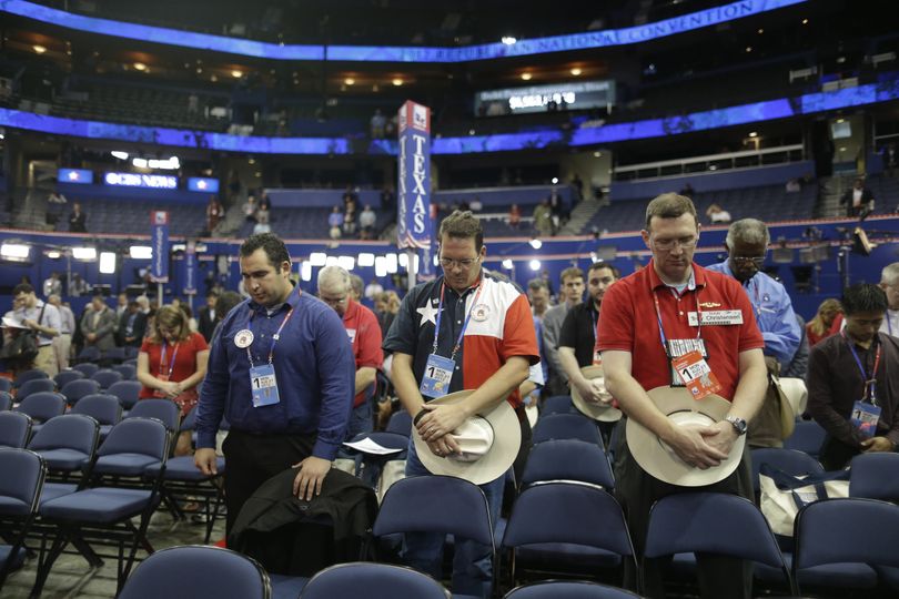 Delegates from Texas pray during an abbreviated session of the Republican National Convention in Tampa, Fla., on Monday, Aug. 27, 2012. (Charles Dharapak / Associated Press)