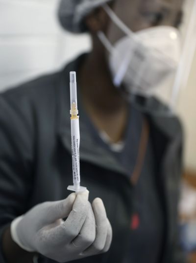 FILE - In this Wednesday, June 24, 2020 file photo, medical staff member prepares a syringe, at the Chris Hani Baragwanath hospital in Soweto, Johannesburg. Politicians and public health leaders have publicly committed to equitably sharing any coronavirus vaccine that works, but the top global initiative to make it happen may allow rich countries to reinforce their own stockpiles while making fewer doses available for poor ones.  (Siphiwe Sibeko)