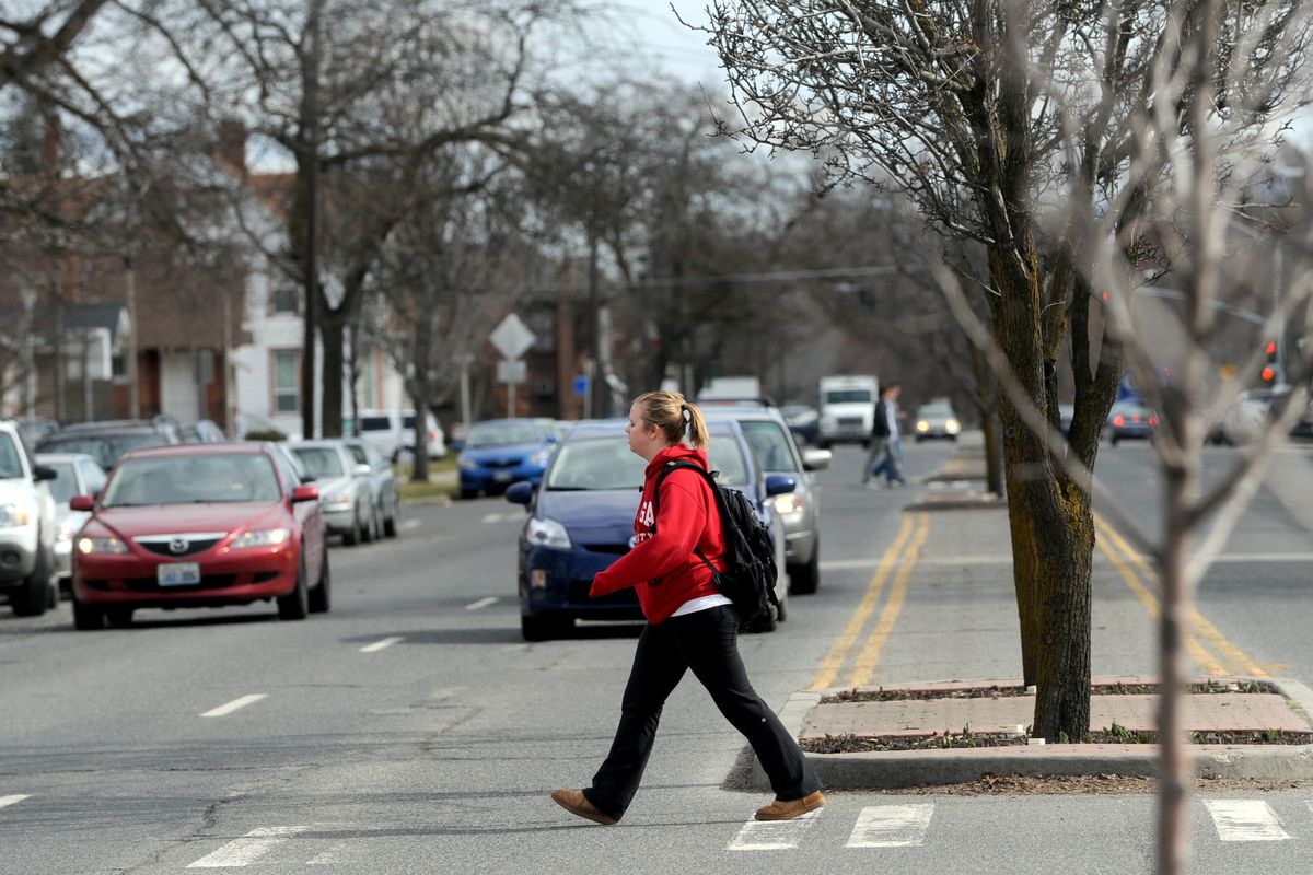 A stream of pedestrians, mostly Gonzaga University students, keeps cars stopping along Sharp Avenue on Friday. (Jesse Tinsley)