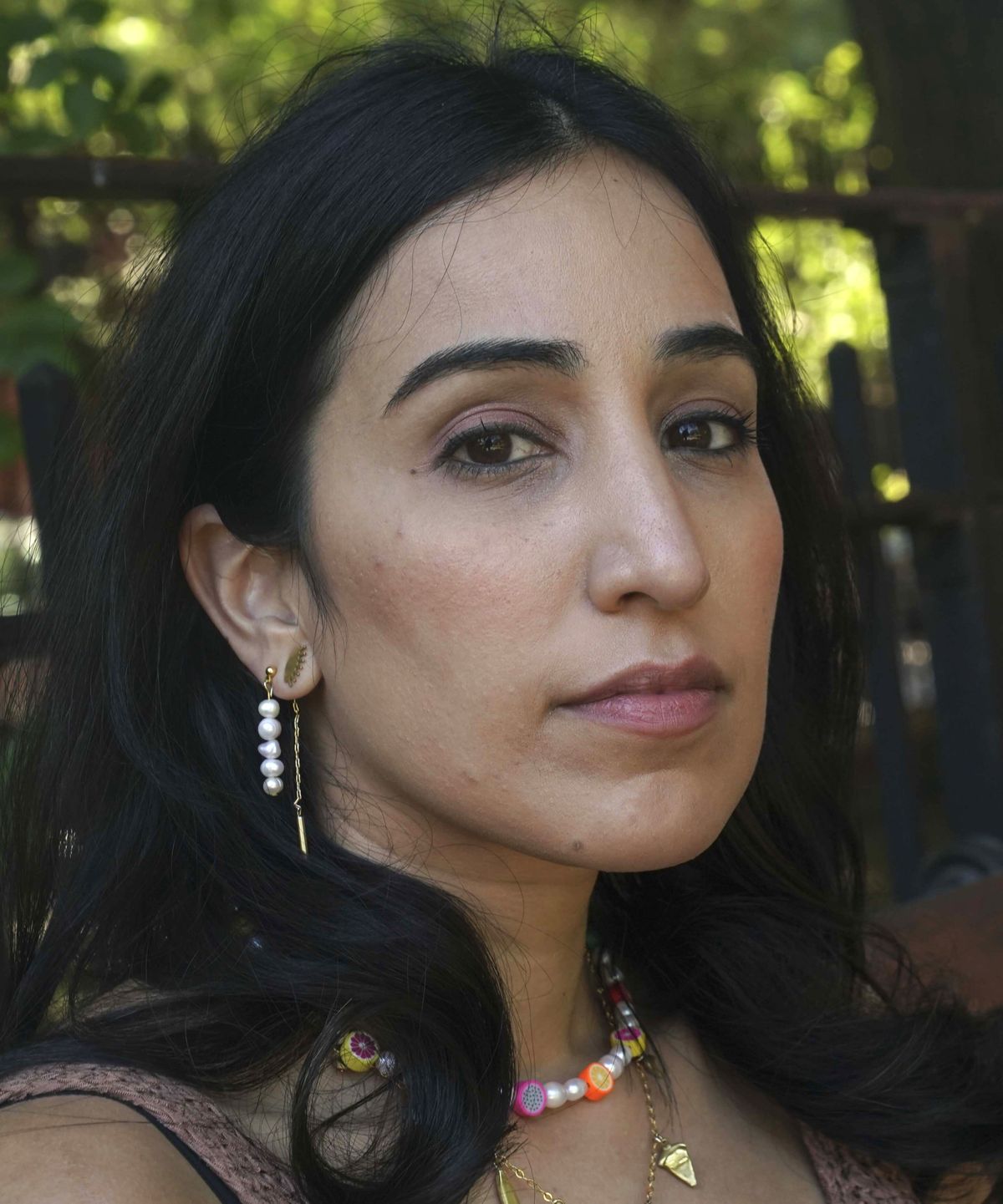 Noreen Wasti sits in a park near her home, Thursday June 24, 2021, in Brooklyn, N.Y. Wasti lost her father Salman Wasti, 76, a retired biology professor from Glocester, R.I., the day after Christmas last year to COVID-19 and is having a hard time going on. "This has been the first time I've lost someone so dear to me, so I never had a map for grief nor really understood the magnitude."  (Bebeto Matthews)