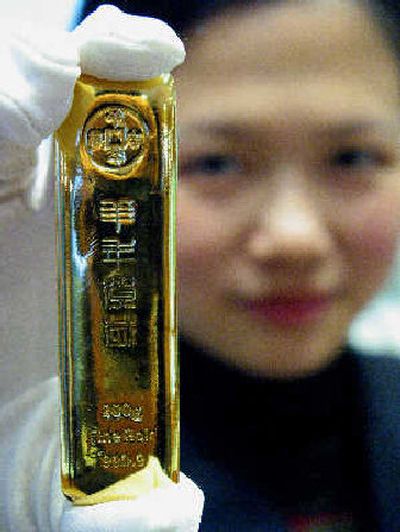 
A Chinese sales woman holds up a 200 gram gold bar on display at a department store in Nanjing, Jiangsu, eastern China. 
 (Associated Press / The Spokesman-Review)