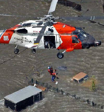 
A resident is rescued from a rooftop by the U.S. Coast Guard on Tuesday as rising floodwaters cover the streets in New Orleans. 
 (The Spokesman-Review)
