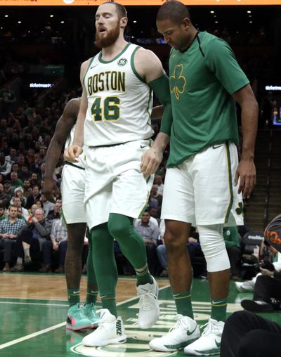 Boston Celtics center Aron Baynes, left, broke his hand in the first quarter of a 111-103 loss to the Phoenix Suns on Wednesday night in Boston. (Elise Amendola / AP)