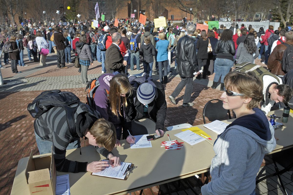 EWU student James Sharr, front left, fills out a voter registration form as a group of several hundred students, faculty and staff rally on the Cheney campus to protest state budget cuts to education on Thursday, Feb. 4, 2010. (Christopher Anderson / The Spokesman-Review)