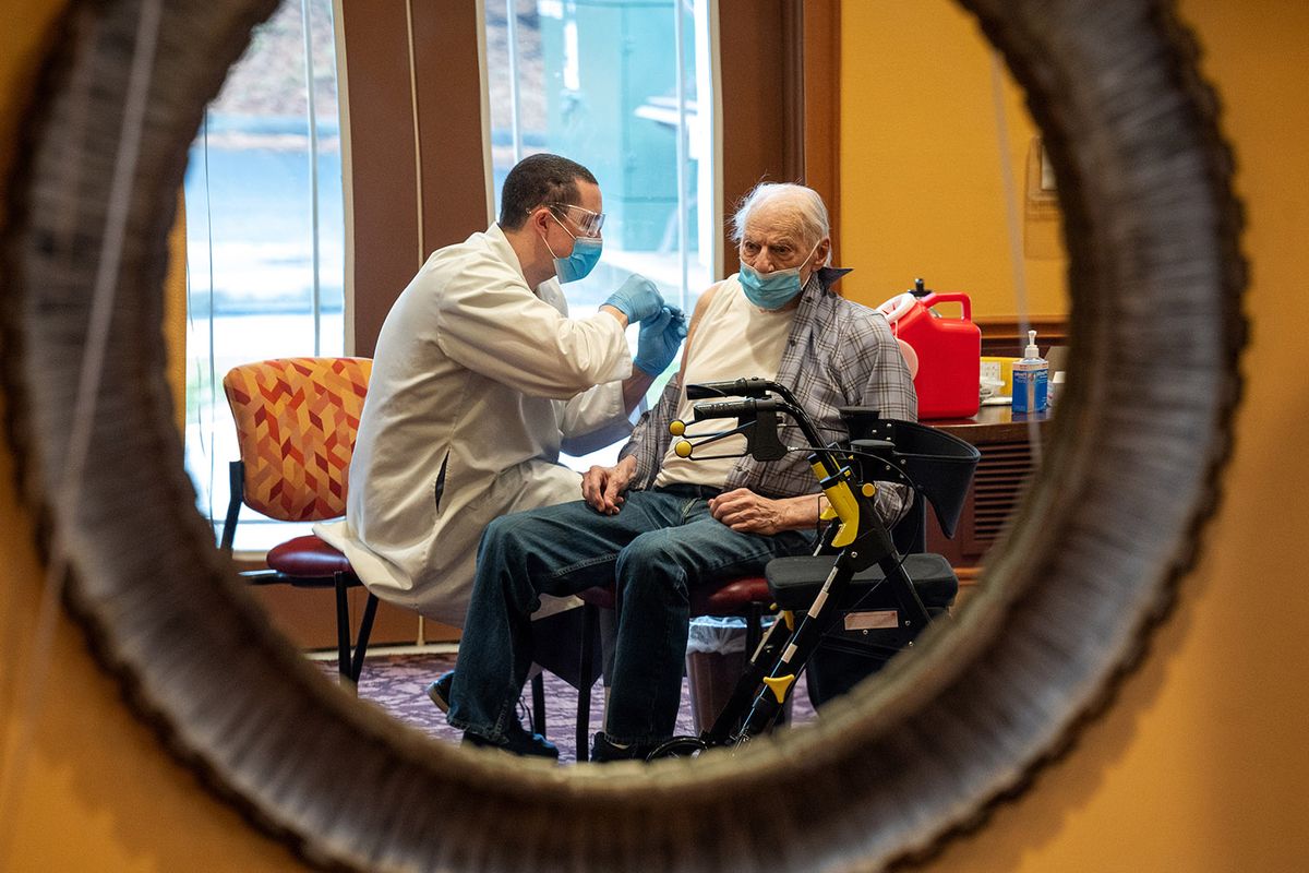 Travis Albo, a pharmacist with Omnicare, gives Wallace McGregor his second dose of the COVID-19 vaccine on Feb. 1 during a mass vaccination at the Fairwinds Retirement Community in Spokane.  (COLIN MULVANY/THE SPOKESMAN-REVIEW)