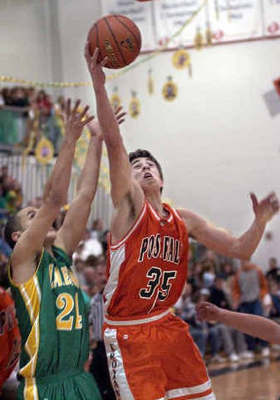 
Post Falls post Ben Den  grabs a rebound over Lakeland's Andrew Bear during the Battle for the Prairie Pig at Post Falls. 
 (Tom Davenport/ / The Spokesman-Review)
