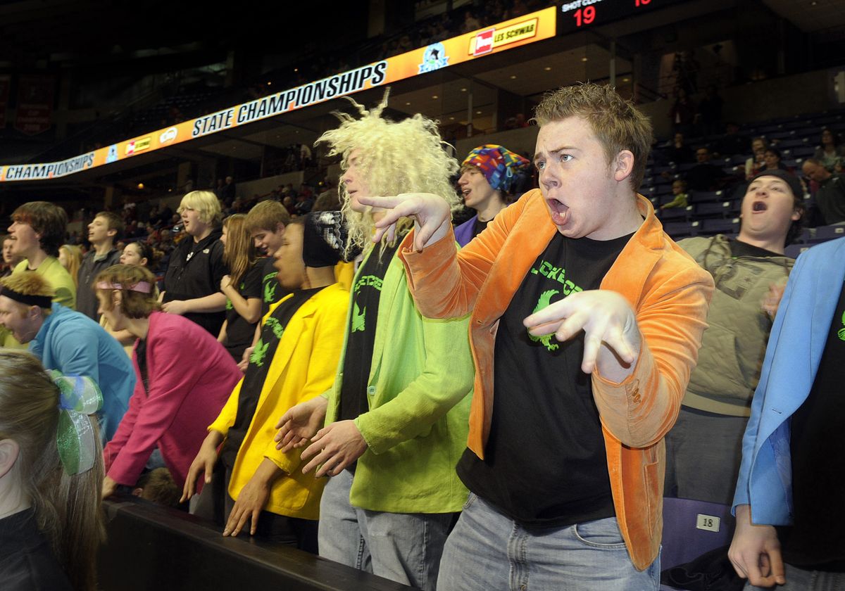 Garrett Butler, in orange, leads a colorful band of fans in a cheer called “The Windstorm” for Evergreen Lutheran during their opening-day game Wednesday in the State 2B Basketball Championships at the Spokane Arena.  Despite fans’ effort, the Evergreen Lutheran girls fell to LaSalle, 49-35.  (CHRISTOPHER ANDERSON / The Spokesman-Review)
