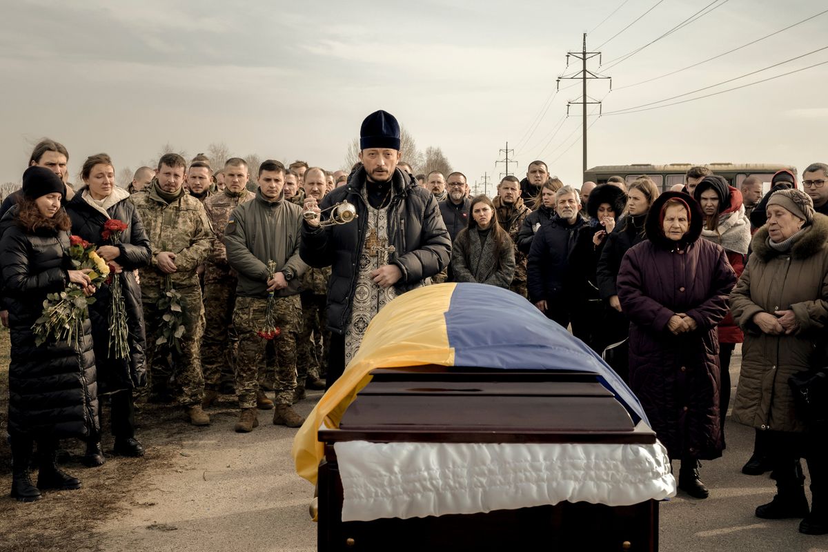Mourners attend the funeral ceremony for Ihor Dyukarev, 24, a Ukrainian soldier who was killed while fighting in the Luhansk region, at a cemetery in Bucha, Ukraine, on Saturday.  (EMILE DUCKE)