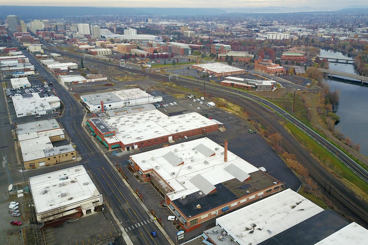 Looking northwest from the 800 block of East Sprague Avenue, the foreground is filled with warehouses, situated near the railroads that once crisscrossed the area, but the new buildings of the University District are seen just above, housing Washington State University’s Health Sciences campus and Eastern Washington classrooms. (Jesse Tinsley / The Spokesman-Review)