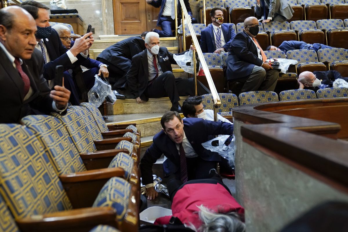 People shelter in the House gallery as protesters try to break into the House Chamber at the U.S. Capitol on Wednesday, Jan. 6, 2021, in Washington.  (Andrew Harnik)