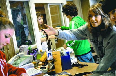 
Rogers High School students Jana Benson, left, and Devann Burney, at window, pick up their student ID cards from student office staff members Mickey Maggard, Laurie Berg and Debby Chandler at Rogers High School. Students at Rogers are required to have their ID tags during the school day.
 (photos by HOLLY PICKETT / The Spokesman-Review)
