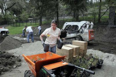 
Tara Newbury takes a load of plants into the Moore-Turner Heritage Gardens at Seventh Avenue and Stevens Street on Monday as workers clean up the last of construction debris. 
 (Photos by CHRISTOPHER ANDERSON / The Spokesman-Review)