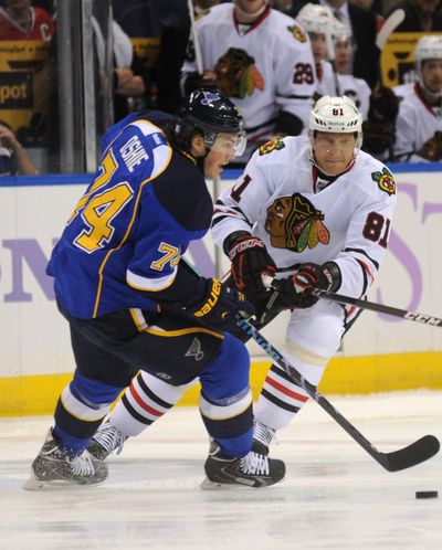 Chicago Blackhawks’ Marian Hossa, right, passes around St. Louis Blues’ T.J. Oshie during first-period action on Wednesday. (Associated Press)