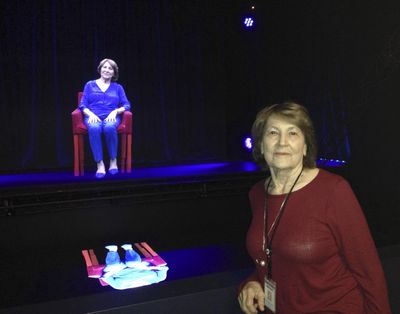 In this Oct. 20, 2017 photo, Holocaust survivor Fritzie Fritzshall poses for a portrait in front of her 3D hologram at the Illinois Holocaust Museum in Skokie, Ill. (Don Babwin / Associated Press)