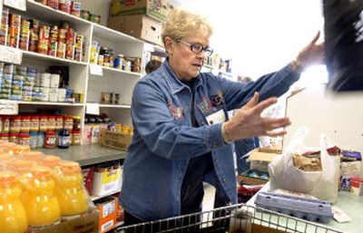 
Volunteer Audrey Knuttel  fills an order  at the Valley Food Bank Wednesday. Dozens of people showed up  before the doors were open to receive food aid. Volunteers said the shelves would be bare in four hours. 
 (JOE BARRENTINE photos / The Spokesman-Review)