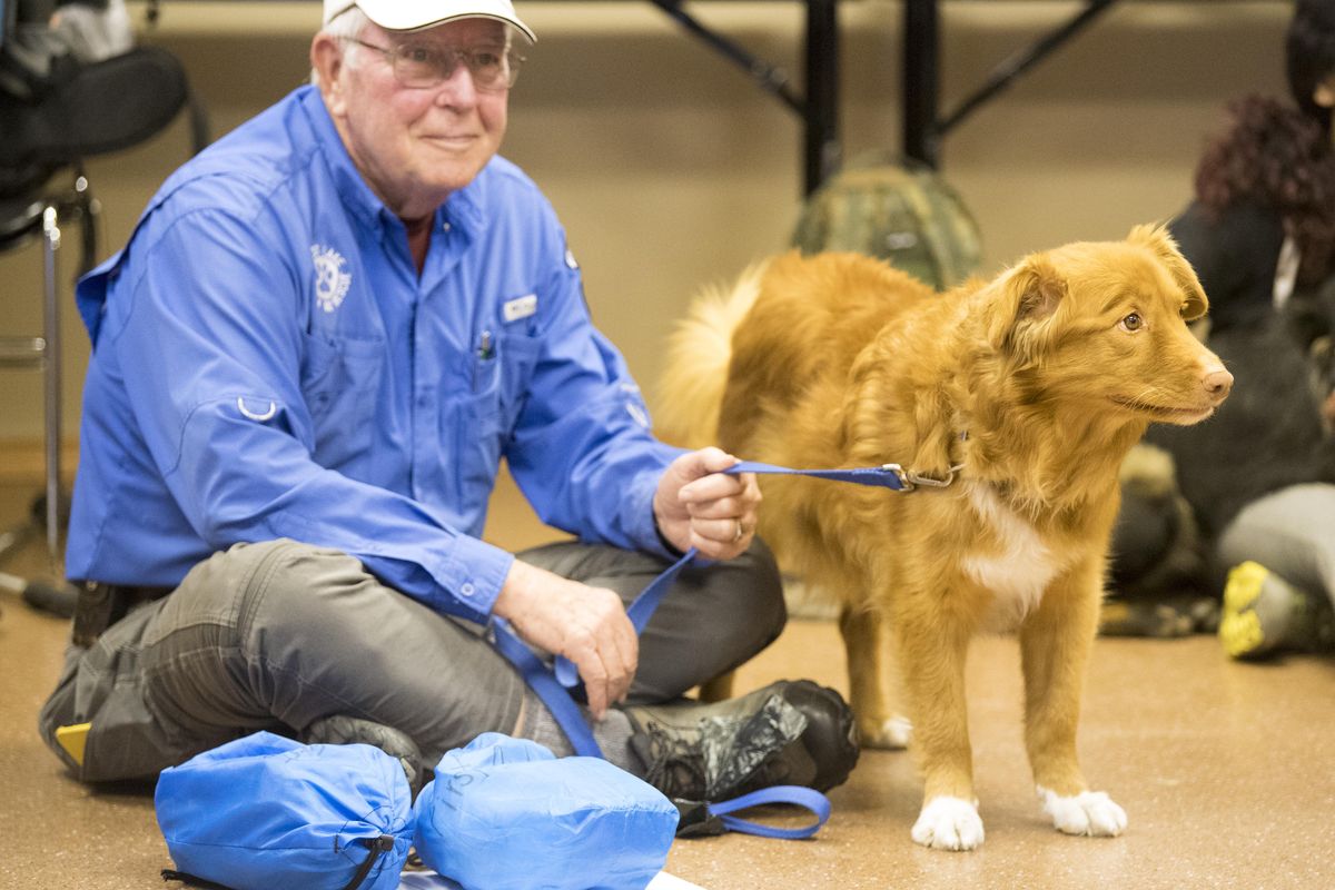 Jim Carlson sits with his dog, Pikka, during a class dog first aid at the Kootenai County Volunteer Search and Rescue building Sunday, March 26, 2017. Pikka is a Nova Scotia duck tolling retriever. (Jesse Tinsley / The Spokesman-Review)