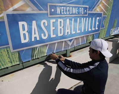 Installer Rene Basilio puts up a banner in left field at Tempe Diablo Stadium, the home of the Los Angeles Angels, in preparation for spring training baseball in Tempe, Ariz., Wednesday, Feb. 17, 2010. Angels pitchers and catchers begin workouts on Thursday. (Eric Risberg / Associated Press)