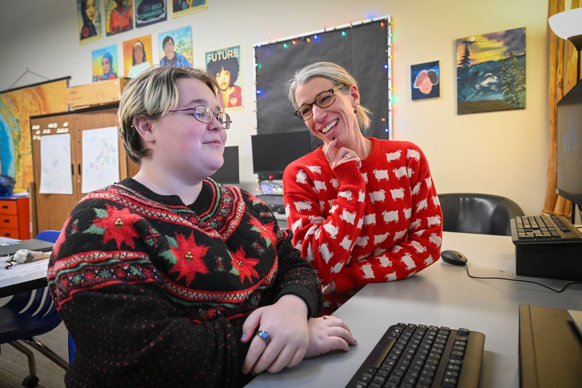Teacher Leslie Heffernan, right, helps AJ Robinson, a senior, use an artificial intelligence website to outline a story for the yearbook at Mica Peak High School in Spokane Valley. The website gave Robinson a list of bullet points to form the story around.  (JESSE TINSLEY/THE SPOKESMAN-REVI)