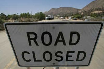 
A road closure sign is seen on Highway 138 in Wrightwood, Calif., on Tuesday.  Drivers upset by a work project subjected  workers to abuse – death threats, BB gun shootings, even a flying burrito. Associated Press
 (Associated Press / The Spokesman-Review)