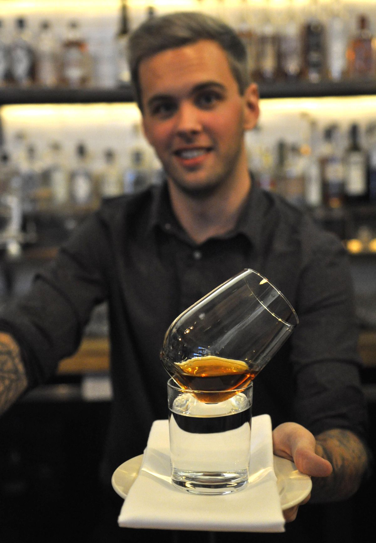 Bartender Cody Winfrey created the towering Snowfall drink, which sits on and is warmed by a cup of steaming hot water. (Adriana Janovich / The Spokesman-Review)