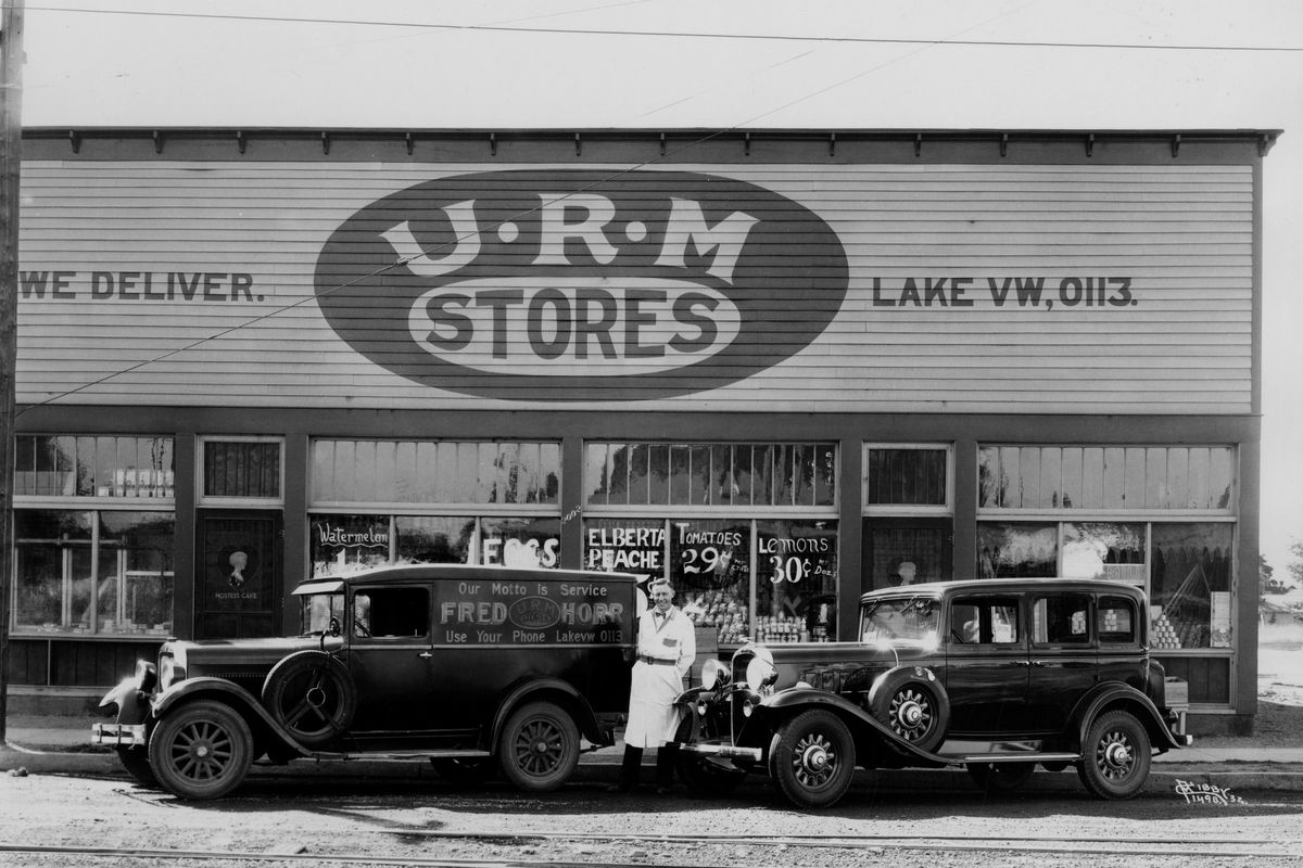 1932: Grocer Fred Horr stands outside his grocery store with his delivery vehicles at the corner of East Boone Avenue and Napa Street in east Spokane. Horr was in the grocery business before United Retail Merchants was formed and joined to help his independent grocery store fill the shelves with fresh produce and nonperishable goods. URM is a customer-owned supplier that  managed to survive the Great Depression and fierce competition from other wholesalers to become one of Washington’s largest companies. Horr died shortly after this photo was taken, but others continued running his store through the 1930s and 1940s. (Libby Collection/Eastern Washington State Historical Society Archives)