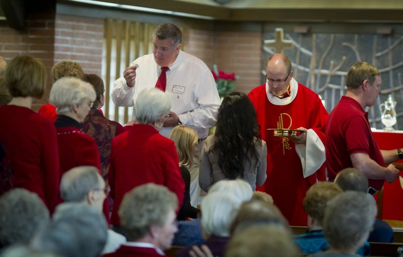 Pastor James Kashork, left, of Holy Trinity Lutheran Church,  and Pastor Matt Larson, of Good Shepard Lutheran Church, give communion during a joint Reformation Sunday worship service at Christ Lutheran Church on Sunday. For several months, three Spokane Valley Lutheran churches – Good Shepherd, Holy Trinity and Christ Lutheran – have been discussing the possibility of merging. This month a majority of all three congregations voted to continue the discussion and create a committee to work out the details.  (Colin Mulvany)