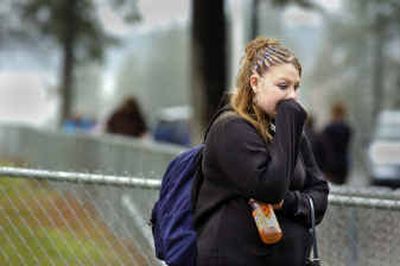 
Lakeside High School student Ciara Dewey waits for her parents to pick her up outside the school Friday in Suncrest. Student Skyler Cullitan  shot himself in the head in the school's entryway Friday afternoon. 