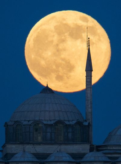 Shining bright: A supermoon rises behind a building of the Topkapi Palace in Istanbul, Turkey, on Sunday. The moon, which reached its full stage Sunday, is expected to be 13.5 percent closer to Earth than usual. (Associated Press)
