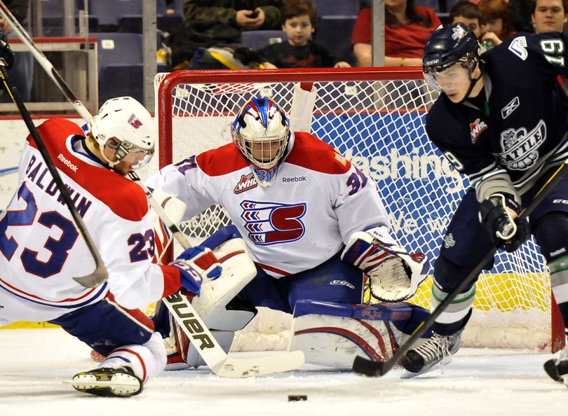 Spokane defender Corbin Baldwin and goalie Mac Engel try to beat Seattle’s Colin Jacobs to loose puck in front of Chiefs’ goal. (Jesse Tinsley)