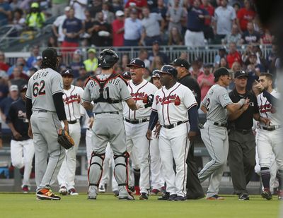 Marlins catcher J.T. Realmuto stands between pitcher Jose Urena, left, and Braves manager Brian Snitker after Urena hit Atlanta rookie Ronald Acuna Jr. with the first pitch of the game on Wednesday. (John Bazemore / AP)