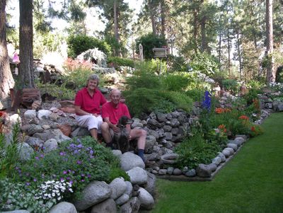 John and Donna Phillips relax on the hand built rock walls of their West Plains garden after winning the June Garden of the Month contest. PAT MUNTS photo (Courtesy photo / The Spokesman-Review)