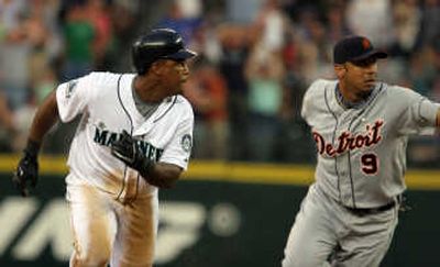 
Seattle's Adrian Beltre runs away from Detroit shortstop Carlos Guillen after hitting a single on which three Mariners scored.Associated Press
 (Associated Press / The Spokesman-Review)