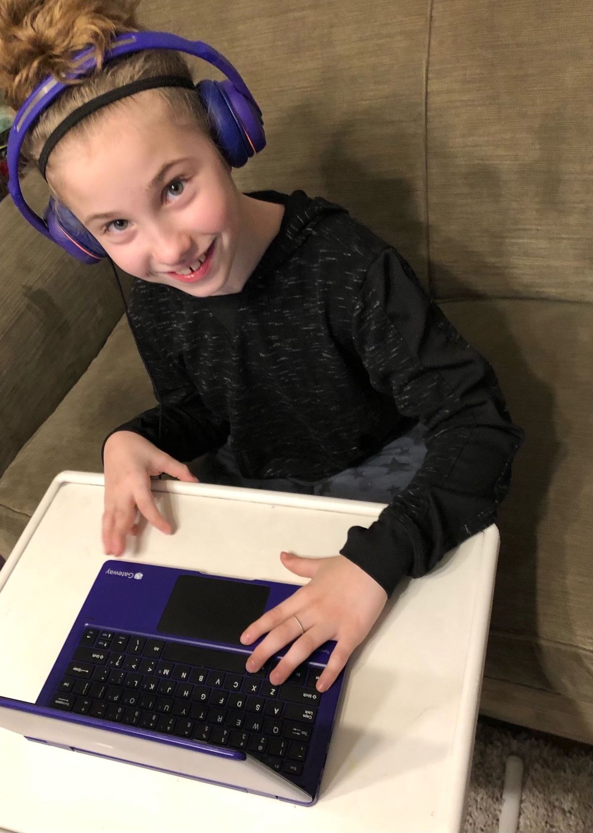 Madelyn Schible, a fourth-grader at Madison Elementary in Spokane, works on her school work from home while a robot at school represents her Tuesday, Dec. 7, 2021. Because she is medically fragile, she attends school via the robot, which she drives through the hallways of the school, watched over by her "bot buddy."   (Photo by Jami Schibel)