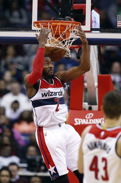 Washington guard John Wall dunks behind his head as Wizards send the Knicks to a franchise-record 13th straight loss. (Associated Press)