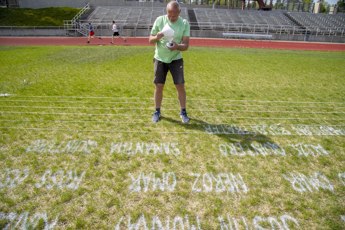 Artist Tom Pettoello works his way through 440 names of graduating seniors while painting them on the field at Ferris High School Monday, May 11, 2020, in Spokane. After creating similar tributes to this year’s seniors at East Valley High School and Rogers High School, Pettoello has been busy with calls to create even more. He estimates that he has done 15 fields, including more than 600 names at one school in Moses Lake. (Jesse Tinsley / The Spokesman-Review)